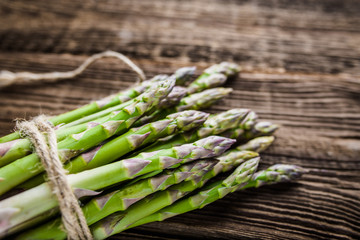 Green asparagus bunch on wooden table, fresh farm vegetable on farmer market