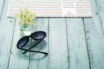keypad, sunglasses and white flower bunch on blue table
