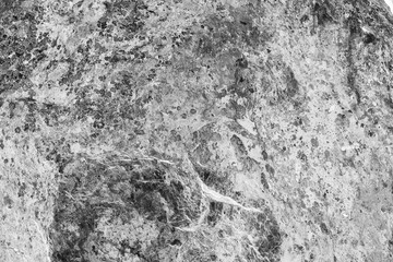 Fototapeta na wymiar Vintage monochrome background. Rough painted wall of black and white color. Imperfect plane of grayscale. Uneven old decorative backdrop. Texture of black-white. Monochromatic ornamental stony surface