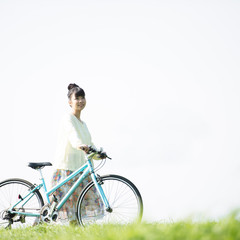 草原で自転車を押す女性