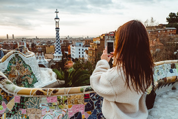 Barcelona signature style. modern tourist woman in coat at Guell Park in Barcelona - obrazy, fototapety, plakaty