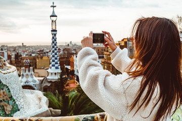 Barcelona signature style. modern tourist woman in coat at Guell Park in Barcelona