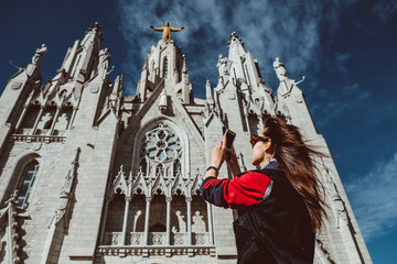 Fototapeta premium Tourist traveler girl on mount Tibidabo look at the Church of Sacred Heart in Barcelona