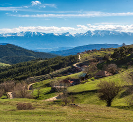 Sunny day over highest village on Balkans and Bulgaria - Ortsevo in Rhodope mountain. High snowy Pirin mountain at background.