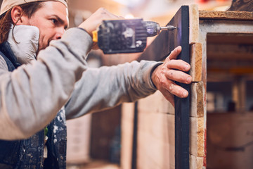 Male carpenter working on old wood in a retro vintage workshop.