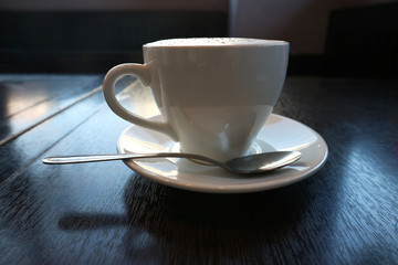 Cappuccino Cup side view stands on the table for design.