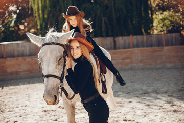 Obraz premium Girls with a horse. Women in a ranch. Blonde in a black sweater