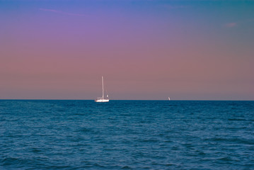 Obraz premium Yachts in the sea against the sunset sky