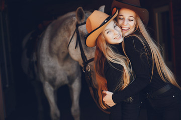 Fototapeta na wymiar Girls with a horse. Women in a ranch. Blonde in a black sweater