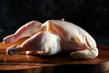 Fresh raw whole chicken on cutting board
