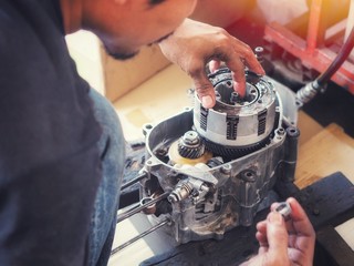 Engine expert Is repairing the engine of a damaged motorcycle To be reused.