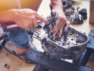 Engine expert Is repairing the engine of a damaged motorcycle To be reused.