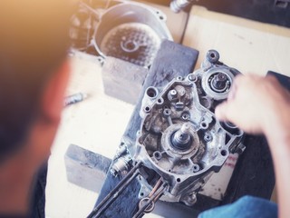 Engine expert Is repairing the engine of a damaged motorcycle To be reused.