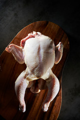 Fresh raw whole chicken on cutting board
