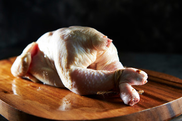 Fresh raw whole chicken on cutting board