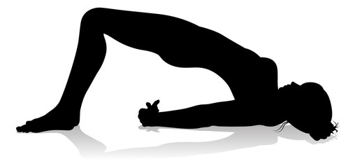 A silhouette of a woman in a yoga or pilates pose 