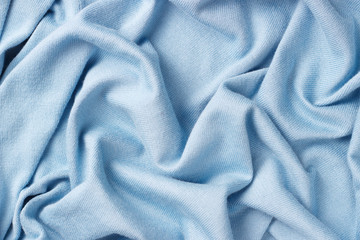 Background of crumpled blue cotton fabric, close-up, knitted texture