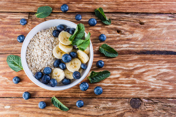 Nice breakfast table. Bowl of blueberries and fruits on a wooden table