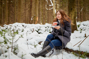 Girl in a pine forest on a winter day