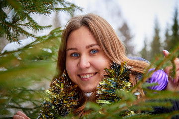 Girl in the winter forest with Christmas toys. Christmas and New year