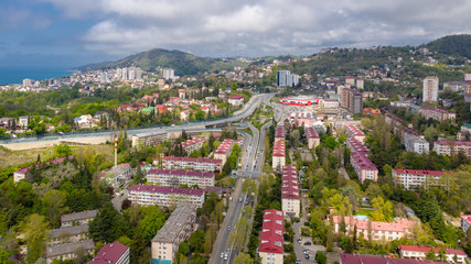 Aerial photography. Urban infrastructure. Dense building. Residential building. Sea view from the window. Coastal town. High-rise buildings on the mountain. The black sea coast of Sochi, Russia.