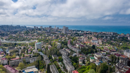 Aerial photography. Urban infrastructure. Dense building. Residential building. Sea view from the window. Coastal town. High-rise buildings on the mountain. The black sea coast of Sochi, Russia.