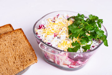 Traditional Russian layered betroot and herring salad (under a fur coat) in glass jar, white background, selective focus