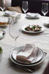 Served for banquet restaurant table with dishes, snack, cutlery, wine and water glasses, european food, selective focus