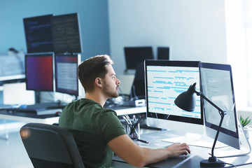 Male programmer working in office - obrazy, fototapety, plakaty