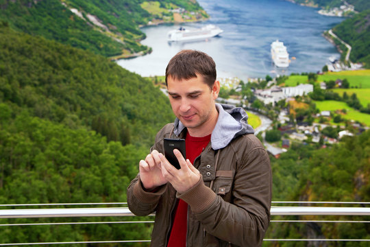 Tourist takes selfie near Geiranger seaport Norway
