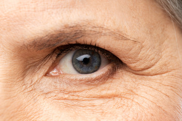 Obraz premium vision, beauty and old age concept - close up of senior woman eye