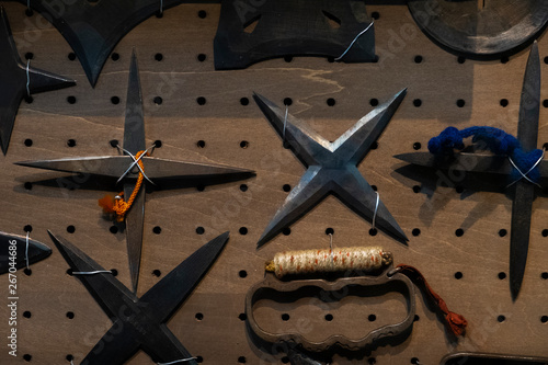Fototapete Closeup Of Collection Of Authentic And Original Rusty Vintage Japanese Shuriken Ninja Throwing Stars And Knuckle Duster Attached To Wall Tobias