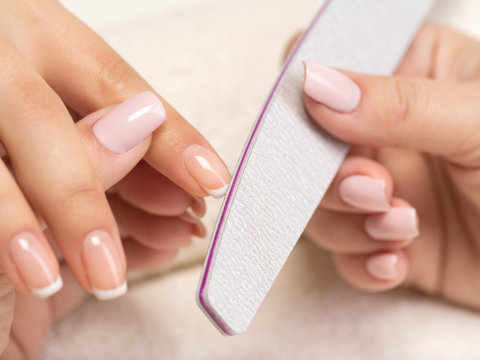 Woman gets manicure procedure in a spa salon. Beautiful female hands.