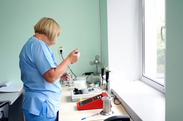 At a hospital laboratory. Lab technician performing analysis of blood samples with gas-electrolyte...