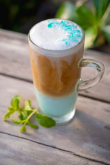 Ice coffee mint in glass with mint leaves on wooden table background.