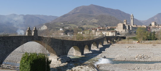 Naklejka premium Devil's bridge in Bobbio. Stone arch bridge over the Trebbia river that was a Roman road in medieval times.