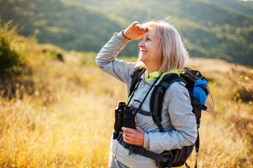 Senior woman is hiking in mountain. Active retirement. 