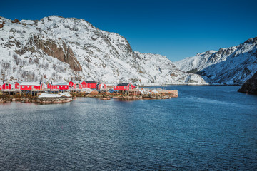 Fishing village with a pier for ships, beautiful houses painted in the national color in Norway