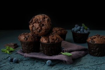 Homemade chocolate muffins with blueberry berries and chocolate drops
