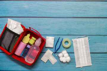 Top view first aid bag kid with medical supplies  on wood background.