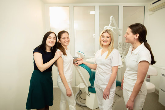A team of professionals in a dental clinic, posing near the equipment