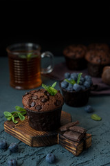 Homemade chocolate muffins with blueberry berries and chocolate drops