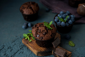 Homemade chocolate muffins with blueberry berries and chocolate drops
