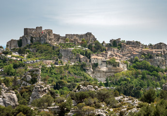 Fototapeta na wymiar An old french castle town stands at the tops of a Rugged cliff, surrounded by forests and rocks. Located in the south of France.