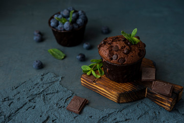 Homemade chocolate muffins with blueberry berries and chocolate drops