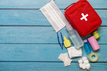 Top view first aid bag kid with medical supplies  on wood background.