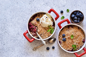 Berry crumble with nuts and ice cream on the kitchen table.