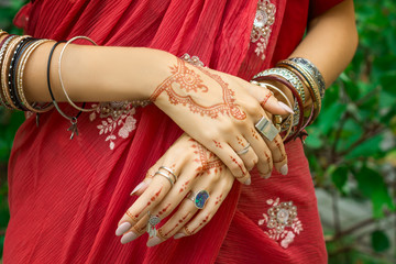 Beautiful woman wear traditional Muslim Arabic Indian wedding red pink sari dress hands with henna tattoo mehndi pattern jewelry and bracelets Happy holiday summer culture festival celebration concept