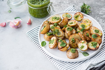 Baked potatoes in rustic style with green pesto sauce