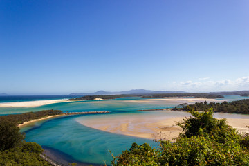 Flat sand dunes at delta of Nambucca river entering Pacific ocean through wide sandy beach of Australian coast around Nambucca heads town - aerial view